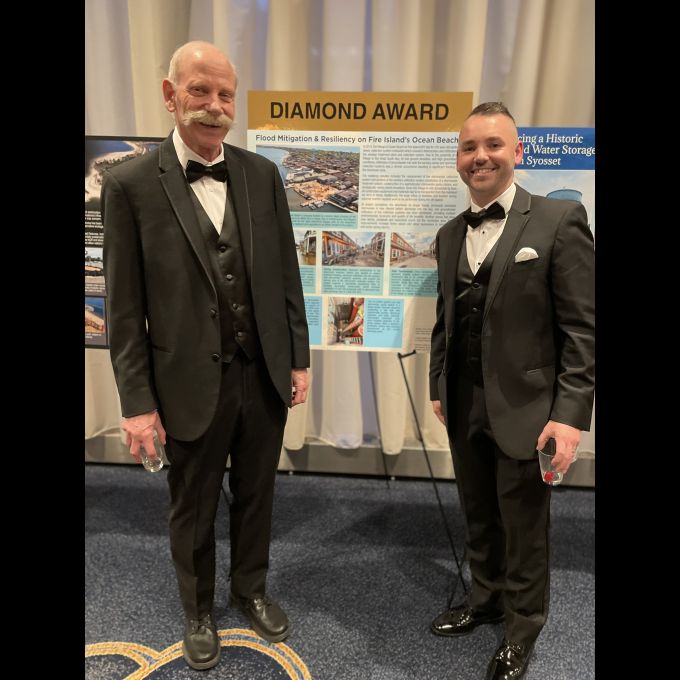 Robert L. Raab, P.E., BCEE, CCM, D&B Senior Vice President and Thomas P. Schaefer, P.E., D&B Senior Associate stand with Diamond Award-winning poster panel for “Ocean Beach Flood Mitigation and Resiliency Project.”
