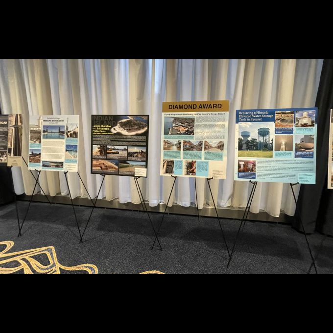 Poster panels created by D&B showcase four ACEC NY Engineering Excellence Award winners: Playland Pool and Bathhouse Rehabilitation Project, Indian Island County Park Living Shoreline Project, Ocean Beach Flood Mitigation and Resiliency Project, and Replacement of 1.5 MG Syosset Elevated Tank Project.